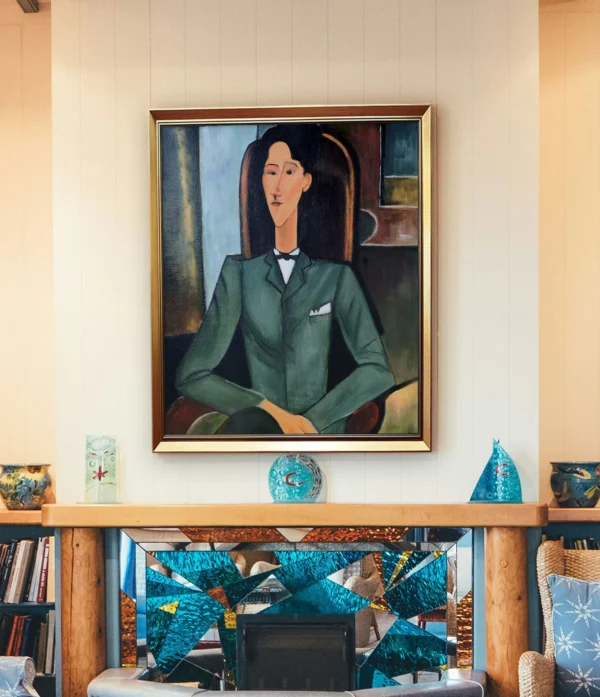 Framed reproduction of Modigliani’s "Portrait of Jean Cocteau" with gold frame, displayed in a modern living room.