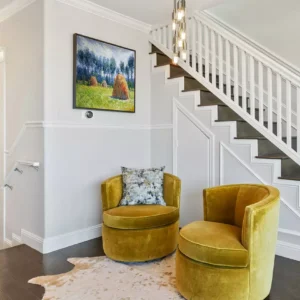 Monet Haystacks reproduction in silver frame above mid-century modern sofa with accent pillows